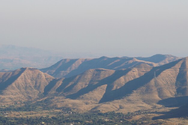 High angle shot of scenery of hills reflecting the rays of the sun under the clear sky