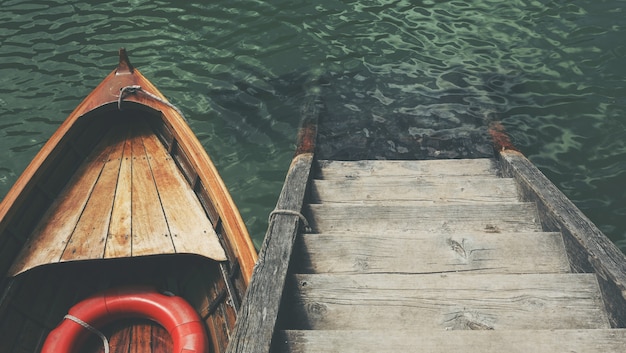 美しい海の木製の階段の近くの小さなボートのハイアングルショット