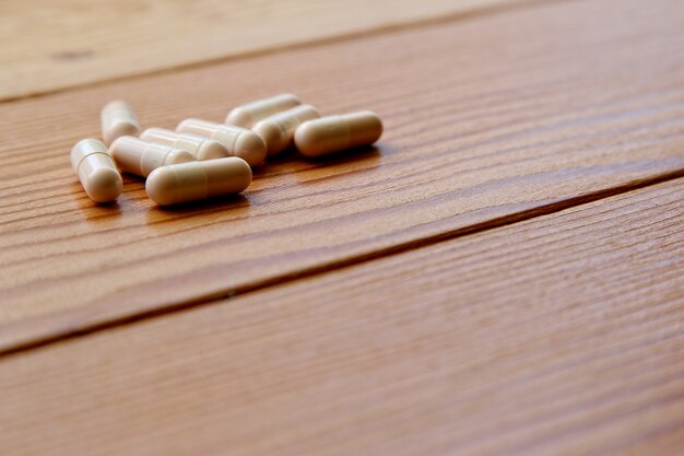 High angle shot of some capsules on a wooden surface