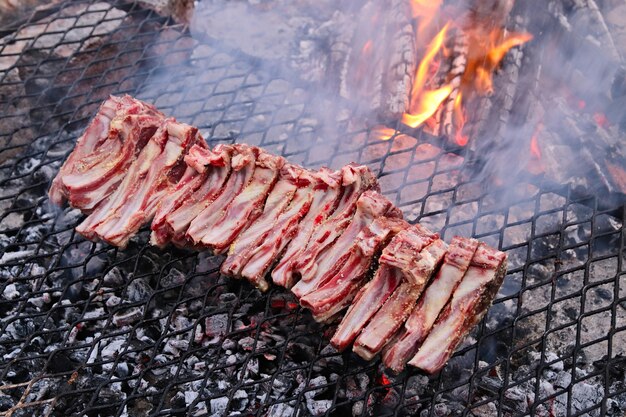 Снимок вкусного мяса, приготовленного на огне на барбекю, под высоким углом