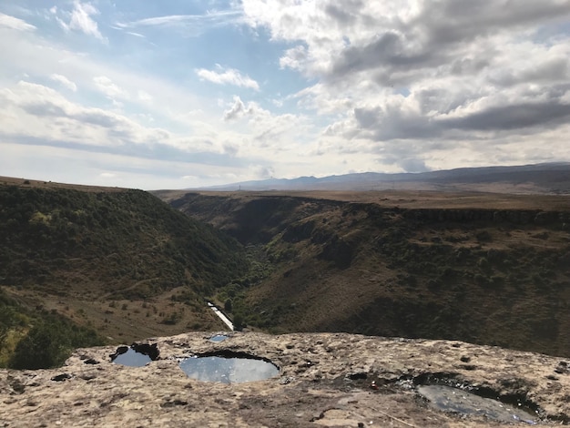 High angle shot of a summit with the breathtaking clouds reflecting in the puddles