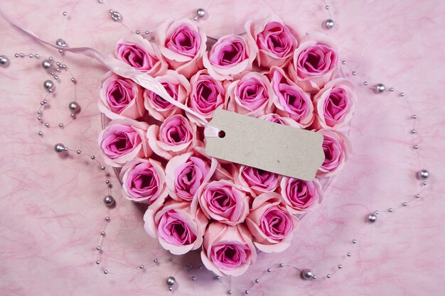 High angle shot of a tag on a beautiful heart-shaped bouquet of pink roses