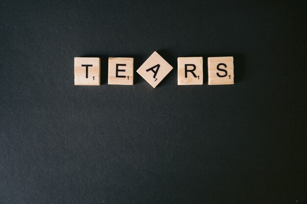 High angle shot of tears message on a black wall