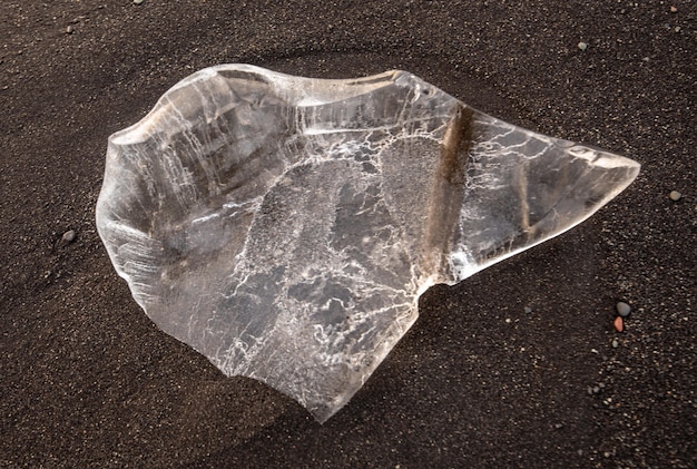 High angle shot of a transparent crystal stone on the soil