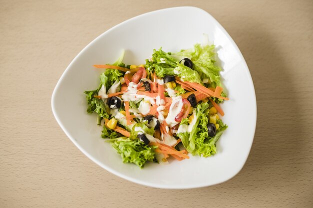 High angle shot of a vegetable salad in a white bowl