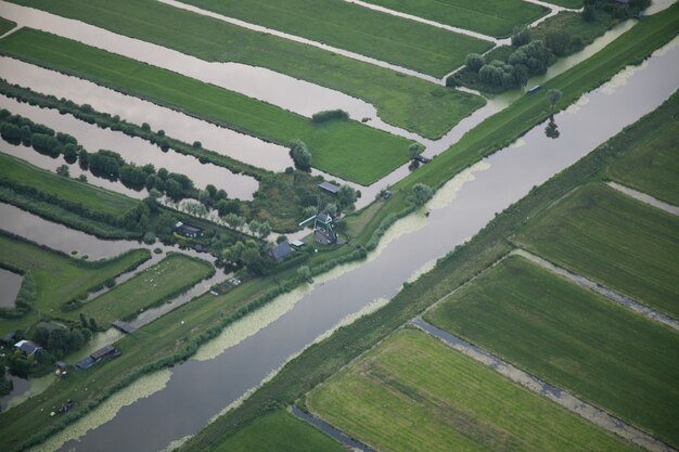 High angle shot of a water stream in the middle of grassy field at Dutch polder