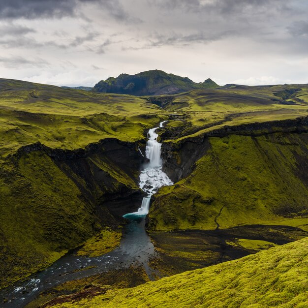 High angle shot of waterfalls in Highlands region of Iceland with a cloudy gray sky