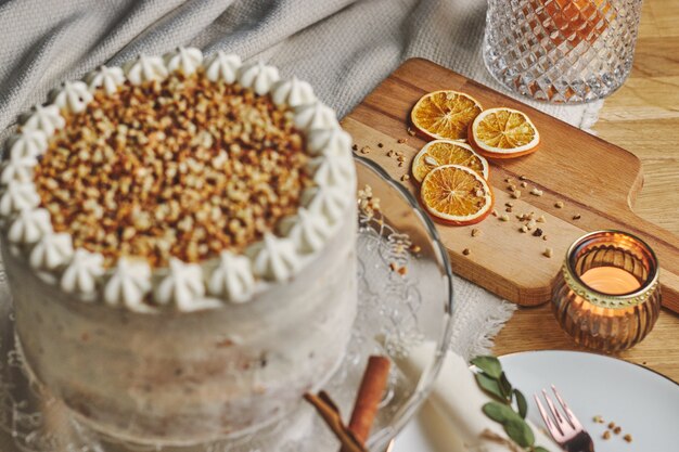 High angle shot of a white delicious Christmas cake with nuts and mandarine