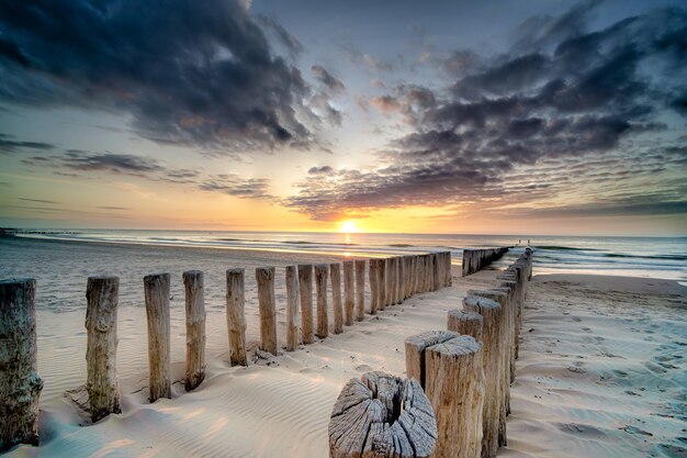 High angle shot of a wooden deck on the shore leading to the sea at sunset