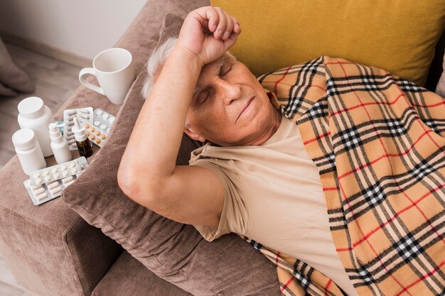 High angle sick man laying on couch