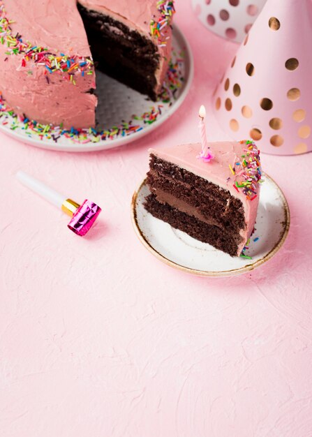 High angle slice of pink cake with candle