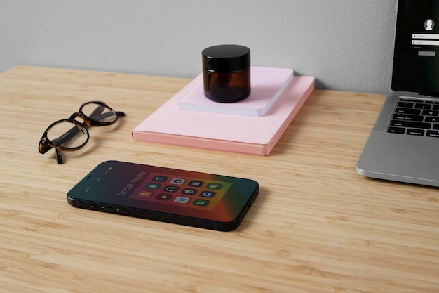 Free photo high angle of smartphone on desk with glasses