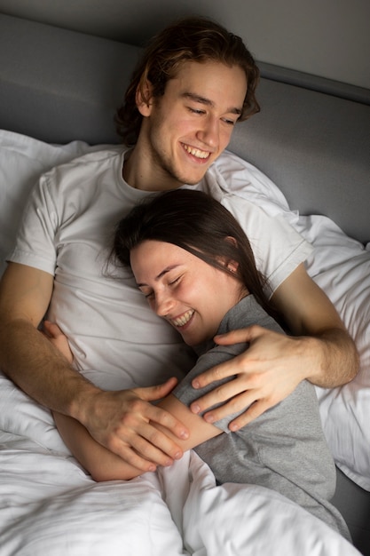 Free photo high angle of smiley couple cuddling