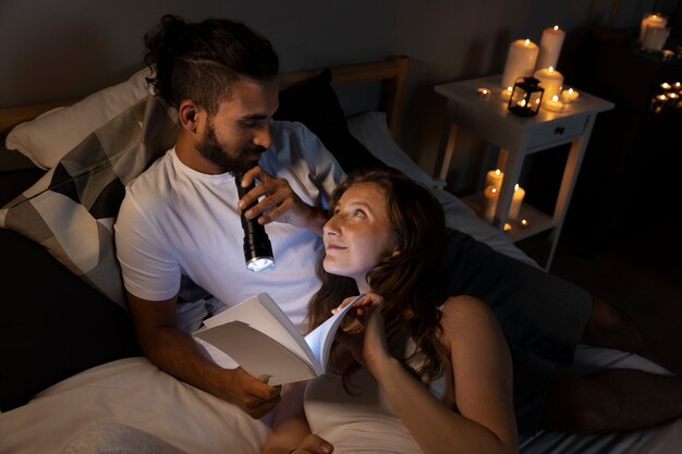 High angle smiley couple laying in bed