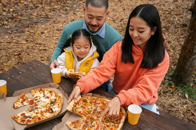 High angle smiley family with delicious pizza