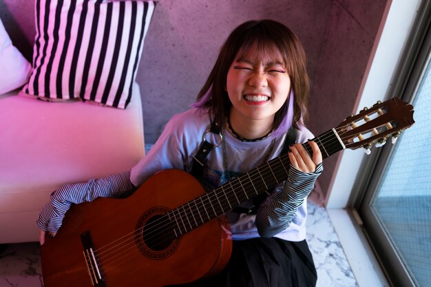 High angle smiley girl holding guitar