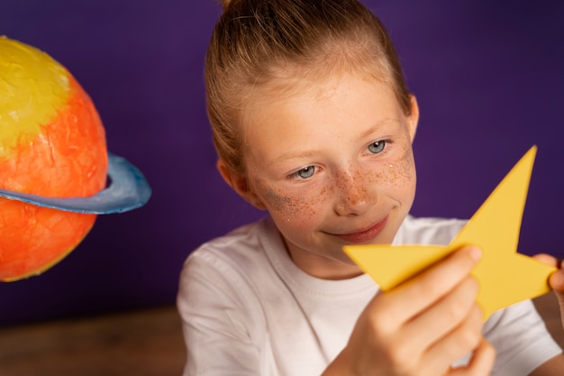 Foto gratuita stella della holding del bambino di smiley dell'angolo alto