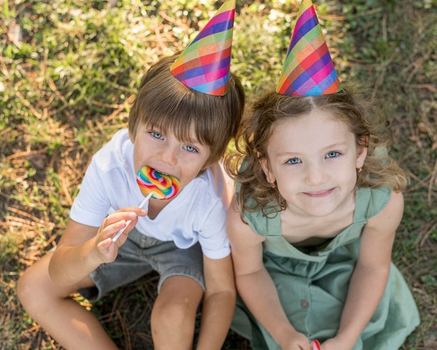 Free photo high angle smiley kids with party hats