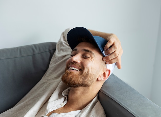 High angle smiley man posing with trucker hat