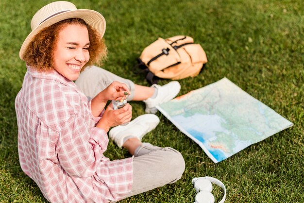 ハイアングルのスマイリー女性が新しい目的地の地図をチェック