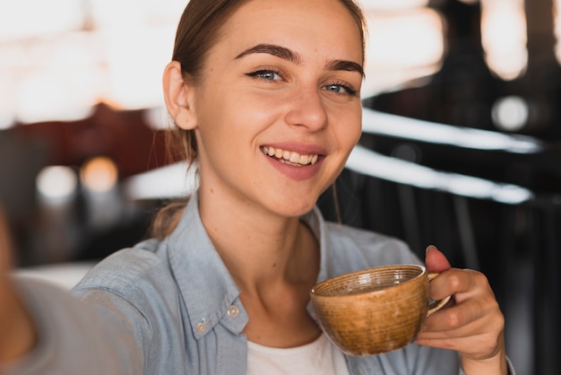 High angle smiley woman drinking coffee