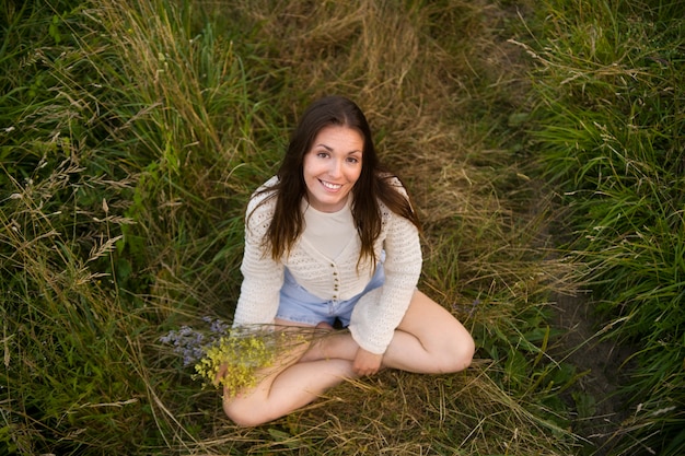 Free photo high angle smiley woman holding flowers