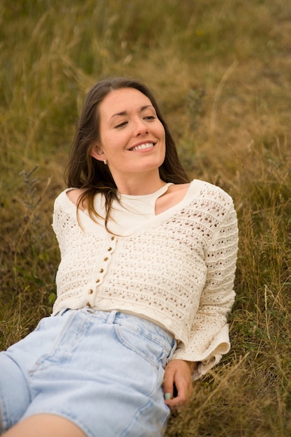 High angle smiley woman laying on grass