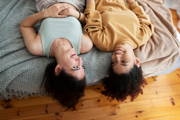 Free photo high angle smiley women laying in bed