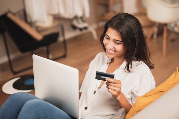 Free photo high angle smiling woman holding a credit card