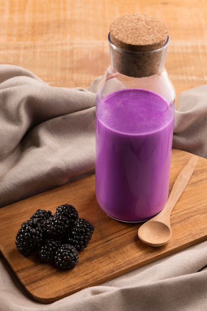High angle smoothie in bottle with blackberries