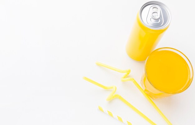 High angle of soft drink can with glass and straws