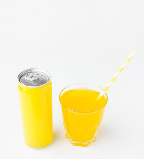 High angle of soft drink can with straw and glass