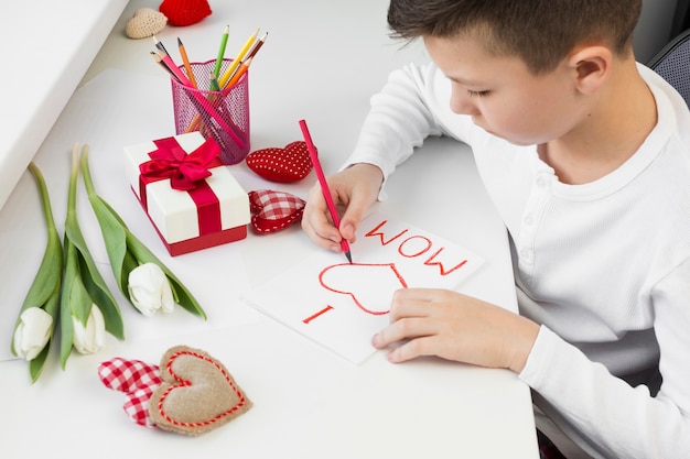 Foto gratuita figlio dell'angolo alto che prepara sorpresa per la mamma