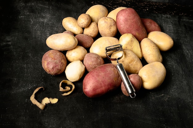 Free photo high angle of stack of potatoes with peeler