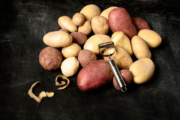 High angle of stack of potatoes with peeler