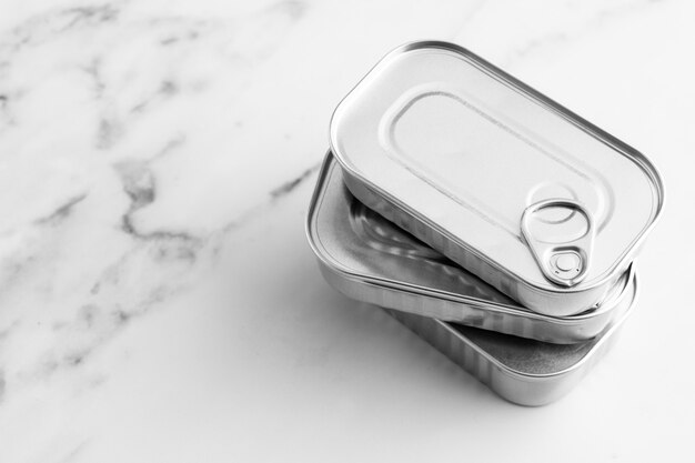 High angle stack of silver tin cans on marble counter