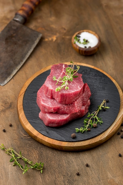 High angle of stacked meat with herbs and salt