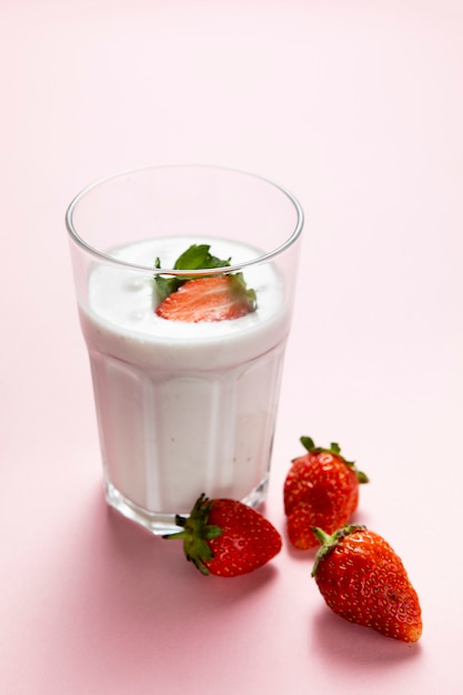 Free photo high angle of stawberry and milk glass on plain background