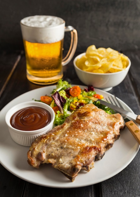 High angle of steak on plate with beer and chips