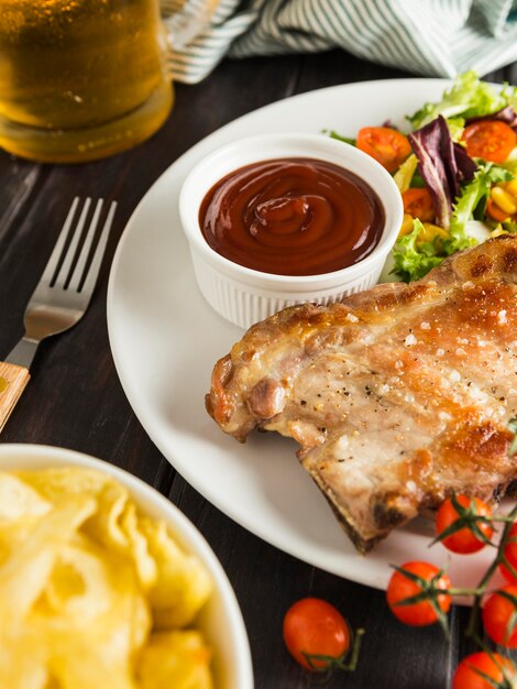 High angle of steak on plate with chips and beer