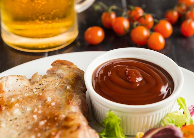 High angle of steak on plate with ketchup and beer