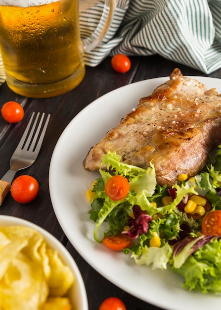 high angle of steak on plate with salad and glass of beer