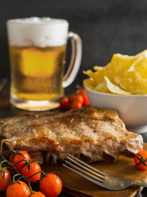 Free photo high angle of steak with beer and chips