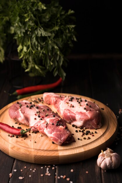 High angle steak on wooden board with salt and pepper