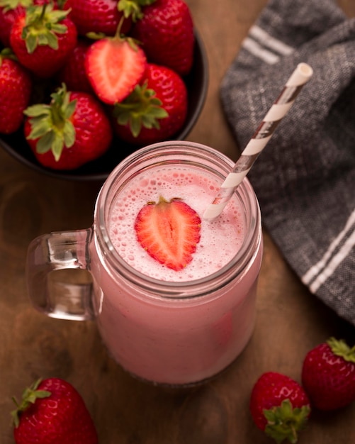 Free photo high angle of strawberry milkshake with straw