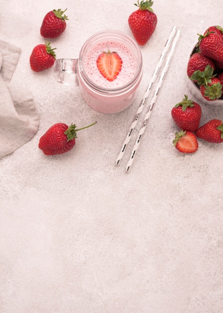 High angle of strawberry milkshake with straws and copy space