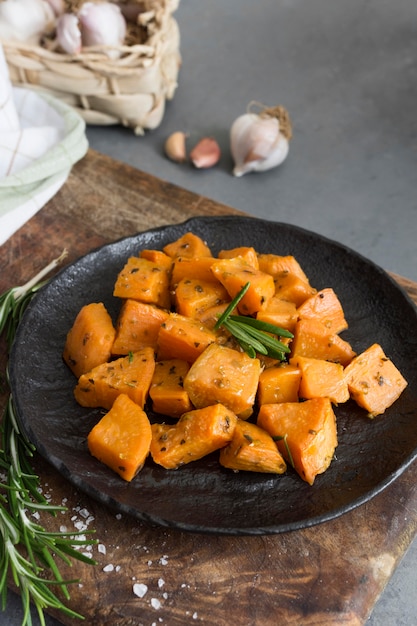 High angle sweet potatoes on black plate