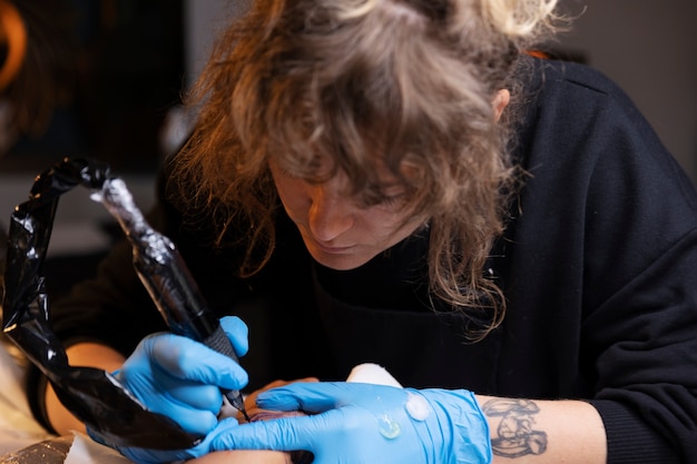 High angle tattoo artist working