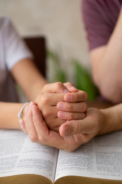 High angle teacher and kid praying together