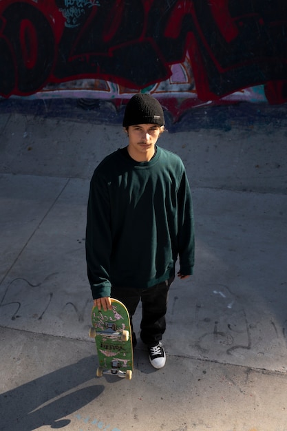 High angle teen holding skateboard